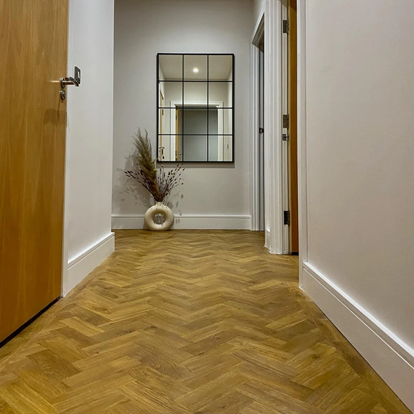 Modern hallway with herringbone floor and window-pane mirror.